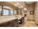 Elegant bathroom with dual sinks, tiled countertops and beautiful arched mirror at 36 Avenida Fiori, Henderson, NV 89011