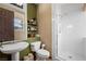 Modern bathroom featuring a pedestal sink, tiled shower, and bright, clean design at 36 Avenida Fiori, Henderson, NV 89011