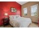 Inviting bedroom featuring a bright red accent wall and decorative windows at 36 Avenida Fiori, Henderson, NV 89011