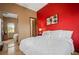 Bright bedroom with a mirrored closet, red accent wall, and a comfortable queen-sized bed at 36 Avenida Fiori, Henderson, NV 89011