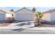Front view of a house with a two-car garage and palm trees at 4634 Skybolt St, Las Vegas, NV 89115