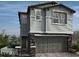Two-story home with gray siding, stone accents, and a two-car garage at 575 Preston Oak, Las Vegas, NV 89138