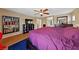 Spacious main bedroom with wood floors, ceiling fan, purple bedspread, and closet at 9331 Hilgard Ave, Las Vegas, NV 89178