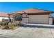 Tan house with tile roof, two-car garage, and front yard landscaping at 1132 Highbury Grove St, Henderson, NV 89002