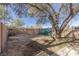 Large backyard with dirt, trees and a green gate at 1200 Cashman Dr, Las Vegas, NV 89102