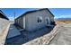 Side exterior featuring a gray single-story building with a sliding glass door and concrete walkway at 1881 Big Horn St, Pahrump, NV 89048