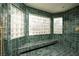 Large walk-in shower with green tile and built in bench at 2031 Mondo Ct, Las Vegas, NV 89123