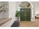 Inviting entryway with green door, arched window, and wood bench at 2031 Mondo Ct, Las Vegas, NV 89123