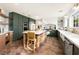 Modern kitchen featuring sleek, green cabinets, stainless steel appliances, and a large island with seating at 2031 Mondo Ct, Las Vegas, NV 89123