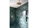 Stylish shower with green tiled walls, a rainfall showerhead, and built-in shelving at 2031 Mondo Ct, Las Vegas, NV 89123