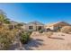 Backyard view of home with covered patio and desert landscaping at 2100 Desert Woods Dr, Henderson, NV 89012