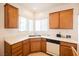 Kitchen corner with wood cabinets, double sink and dishwasher at 2100 Desert Woods Dr, Henderson, NV 89012