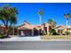 Tan house with brown garage door, landscaping, and palm trees at 2145 Sierra Heights Dr, Las Vegas, NV 89134