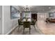 Modern dining room with glass top table, green chairs, and a large abstract painting at 2617 Mason Ave, Las Vegas, NV 89102