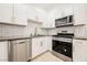 Modern kitchen with white cabinets, gray countertops, and stainless steel appliances at 3263 Gold Run St, North Las Vegas, NV 89032