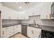 Modern kitchen with white cabinets, stainless steel appliances, and a gray quartz countertop at 3263 Gold Run St, North Las Vegas, NV 89032