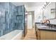 Stylish bathroom with blue tile, a bathtub, and a modern vanity at 3517 Spencer St, Las Vegas, NV 89169