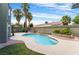 Private backyard oasis features a sparkling pool, lush lawn, and mature palm trees creating a serene atmosphere at 6112 Browning Way, Las Vegas, NV 89130