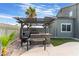 Inviting outdoor kitchen and dining area featuring a built-in grill, bar, and pergola, perfect for entertaining at 6112 Browning Way, Las Vegas, NV 89130