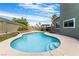 Inviting in-ground pool with baja shelf surrounded by low-maintenance landscaping and convenient outdoor kitchen at 6112 Browning Way, Las Vegas, NV 89130