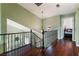 Upstairs hall with dark hardwood floors and wrought-iron railings overlooking the living room at 6112 Browning Way, Las Vegas, NV 89130
