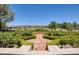 Landscaped backyard with rose garden, stone patio, and golf course view at 66 Innisbrook Ave, Las Vegas, NV 89113