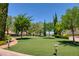 Landscaped backyard with lush lawn, stone pathway, and mature trees at 66 Innisbrook Ave, Las Vegas, NV 89113