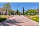 Brick-paved road leads to a gated community entrance with manicured landscaping at 66 Innisbrook Ave, Las Vegas, NV 89113