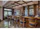 Well-appointed home bar with wood cabinetry, glass shelving, and bar stools at 66 Innisbrook Ave, Las Vegas, NV 89113