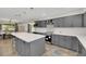 Modern kitchen with gray cabinets, quartz island, and pendant lighting at 8870 W Craig Rd, Las Vegas, NV 89129
