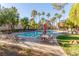 Community pool with lounge chairs, tables, and umbrellas, surrounded by palm trees at 9000 Las Vegas Blvd # 1016, Las Vegas, NV 89123