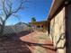 Home's backyard with covered patio area, with brick trim and concrete at 111 Manganese St, Henderson, NV 89015