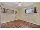 A bright bedroom with hardwood floors, neutral paint, ceiling fan and lots of light from two windows at 111 Manganese St, Henderson, NV 89015