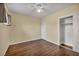 A cozy bedroom with hardwood floors, closet, neutral paint, ceiling fan and a bright open window at 111 Manganese St, Henderson, NV 89015