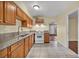 Cozy kitchen featuring wooden cabinets, granite countertops, white appliances, and tile flooring at 111 Manganese St, Henderson, NV 89015