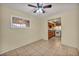 Bright living room with neutral walls, ceiling fan, tile flooring, and view to kitchen at 111 Manganese St, Henderson, NV 89015