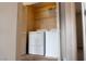 A laundry closet with white washer and dryer units and storage shelves at 1158 Safari Creek Dr, Henderson, NV 89002