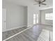 Spacious bedroom with wood floors, a ceiling fan, and natural light from the sliding glass doors at 2140 Upland Ave, Pahrump, NV 89048