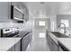 Stylish kitchen featuring stainless steel appliances, sleek gray cabinets, and luxurious marble flooring at 2140 Upland Ave, Pahrump, NV 89048