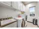 Bright laundry room with washer, dryer, sink, and ample cabinetry at 282 E Maulding Ave, Las Vegas, NV 89123