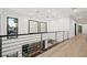 Bright hallway featuring light wood floors and a metal railing overlooking living area at 2824 Queens Courtyard Dr, Las Vegas, NV 89109