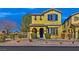 Beautiful two-story yellow house with blue door and landscaping at 4356 Hera Temple Ave, North Las Vegas, NV 89031