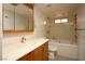 A clean, tiled bathroom featuring a bath tub, toilet and a wood vanity with mirror at 71 E Atlantic Ave, Henderson, NV 89015