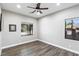 Well lit room with two windows and dark wood floors at 8075 Palm Cove Ct, Las Vegas, NV 89129