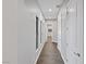 Long hallway with wood flooring and neutral-colored walls at 8075 Palm Cove Ct, Las Vegas, NV 89129