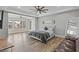 Spacious main bedroom featuring wood floors, a stylish ceiling fan, and a comfortable seating area at 8075 Palm Cove Ct, Las Vegas, NV 89129