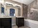 Bathroom with double sinks, dark vanity, and a bathtub at 9801 Fast Elk St, Las Vegas, NV 89143