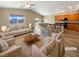 Virtually staged living room features a beige sofa and hardwood floors at 9801 Fast Elk St, Las Vegas, NV 89143