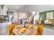 Modern dining area with a round table, yellow chairs, and an open kitchen view at , North Las Vegas, NV 89084