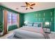 Cozy bedroom featuring vibrant green walls, a large window, and elegant decor at 10997 Sardinia Sands Dr, Las Vegas, NV 89141